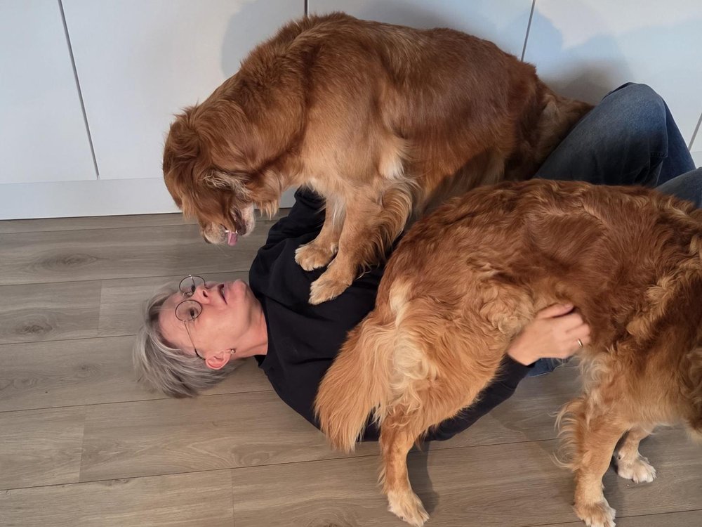 Anne-Louise ligger på gulvet og leger med Hollie og Frit
